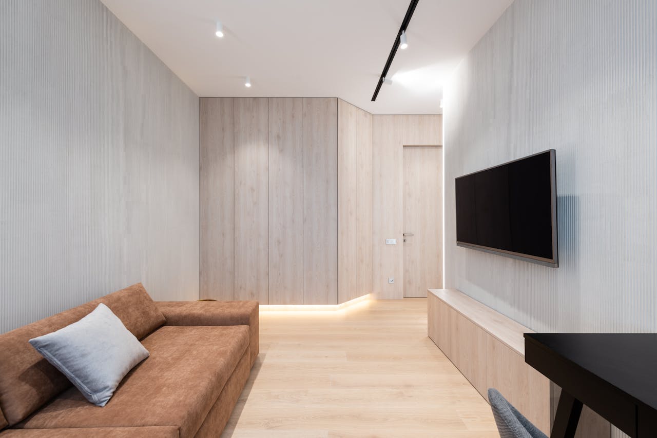 about-img Interior of modern living room with sofa with pillow and TV on wall next to table